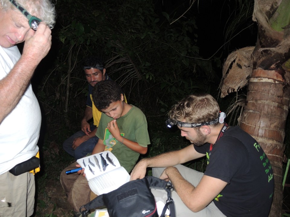 This shows some of the people waiting to go check the net over the stream. The young man with the book is the son of the guide (behind him).